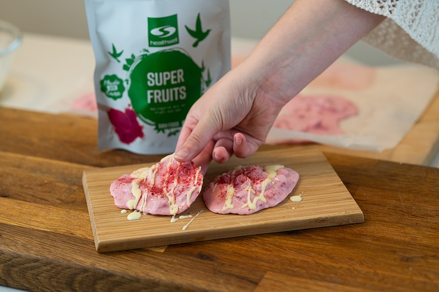 Kvinde, der tager en frozen yoghurtbite op fra en tr�bakke. 